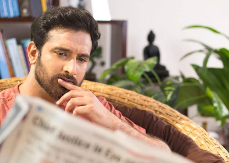 Hombre leyendo periódico financiero