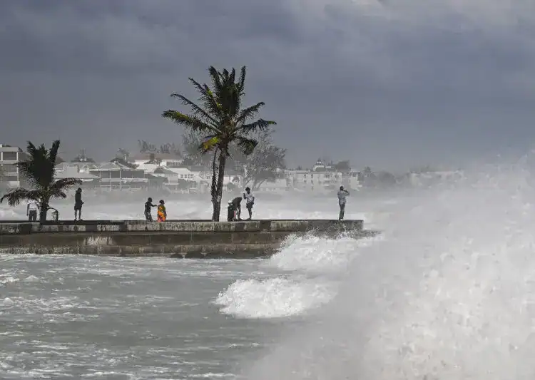 Personas en la costa viendo los cambios del clima cerca de Bridgetown, Barbados, el1 de julio de 2024, por los efectos del huracán BerylCHANDAN KHANNA / AFP)
