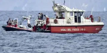 Buzos de los bomberos italianos llevan hasta un barco la bolsa con los restos mortales de una de las víctimas del naufragio del yate Bayesian, el 21 de agosto de 2024, en Porticello, cerca de Palermo, en el sur de Italia. (AP Foto/Salvatore Cavalli)