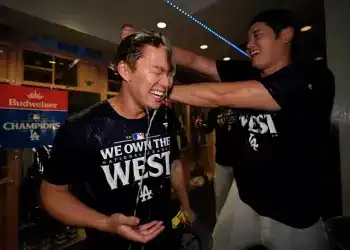 El japonés Shohei Ohtani, bateador designado de los Dodgers de Los Ángeles, arroja champaña encima de su compatriota Yoshinobu Yamamoto, luego de la conquista del cetro de la División Oeste de la Liga Nacional con un triunfo sobre los Padres de San Diego, el jueves 26 de septiembre de 2024 (AP Foto/Ashley Landis)