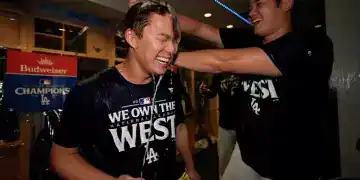 El japonés Shohei Ohtani, bateador designado de los Dodgers de Los Ángeles, arroja champaña encima de su compatriota Yoshinobu Yamamoto, luego de la conquista del cetro de la División Oeste de la Liga Nacional con un triunfo sobre los Padres de San Diego, el jueves 26 de septiembre de 2024 (AP Foto/Ashley Landis)