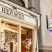 Londres, Reino Unido, 13 de septiembre de 2024: Hermes frente a la tienda y escaparate. Ubicado en 1213 Royal Exchange, Londres EC3V 3LL. Distribuidor de gama alta que lleva la ropa, los bolsos y las bufandas de la marca de lujo.