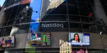 Stock market news displayed on a television at the Nasdaq MarketSite in New York, US, on Tuesday, March 11, 2025. The stock market on Monday shifted towards defensive sectors such as energy, consumer staples, and utility companies, which tend to fare well during recessions, as investors sought shelter from the potential economic storm. Photographer: Michael Nagle/Bloomberg via Getty Images