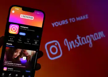 Hombre sostiene el teléfono inteligente con la aplicación de Instagram en la pantalla. Instagram es un App para compartir fotos para smartphones.