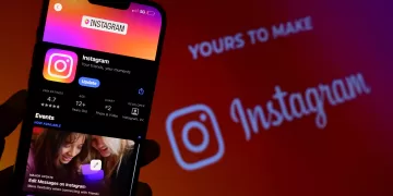 Hombre sostiene el teléfono inteligente con la aplicación de Instagram en la pantalla. Instagram es un App para compartir fotos para smartphones.