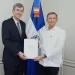 El embajador de Rusia entrega sus cartas credenciales al canciller de República Dominicana, con la bandera dominicana al fondo.