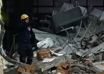 A rescuer stands amid debris at the Jet Set nightclub -which roof collapsed two days ago- in Santo Domingo on April 10, 2025. The death toll in the collapse has reached 218, security forces reported, as they concentrate on finding the last bodies in the area of the tragedy. More than 500 people were injured in the incident. (Photo by MARTIN BERNETTI / AFP) (Photo by MARTIN BERNETTI/AFP via Getty Images)