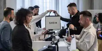 MILAN, ITALY - APRIL 17: A saleswoman handles a bag to a customer at the SHEIN’s “Spring Boutique” temporary store at Palazzo dei Giureconsulti on March 23, 2024 in Milan, Italy. SHEIN, a Chinese e-commerce platform specialized in ultra fast fashion, frequently holds temporary "pop-up" stores to allow customers to experience their products in person and to interact with the brand offline. (Photo by Emanuele Cremaschi/Getty Images)
