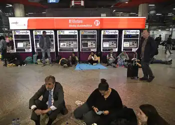 MADRID, SPAIN - APRIL 28: People wait in front of the Atocha train station for services to return to normal as a widespread power outage strikes Spain and Portugal around midday in Madrid, Spain on April 28, 2025. Amid a massive blackout, Spain's Prime Minister Pedro Sanchez on Monday announced a state of emergency in the regions of Madrid, Andalusia, and Extremadura. Transportation has been severely disrupted and many areas in Spain have endured nearly nine hours without power. (Photo by Burak Akbulut/Anadolu via Getty Images)