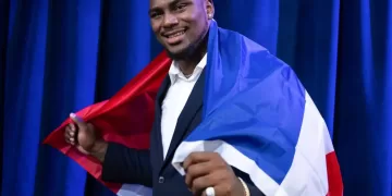 Bayron Matos sosteniendo una bandera de República Dominicana en la espalda