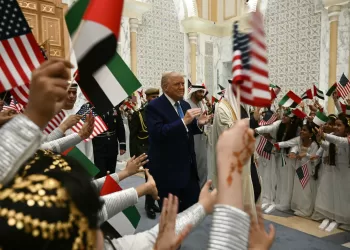 Children wave Emirati and US flags as US President Donald Trump arrives at Qasr Al-Watan (Palace of the Nation) in Abu Dhabi on May 15, 2025. The United Arab Emirates is the third leg of Trump's visit to the region, which has already taken him to Saudi Arabia and Qatar. (Photo by Brendan SMIALOWSKI / AFP)