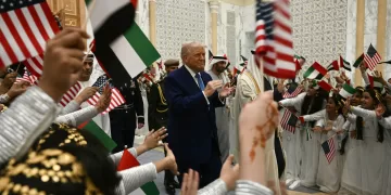 Children wave Emirati and US flags as US President Donald Trump arrives at Qasr Al-Watan (Palace of the Nation) in Abu Dhabi on May 15, 2025. The United Arab Emirates is the third leg of Trump's visit to the region, which has already taken him to Saudi Arabia and Qatar. (Photo by Brendan SMIALOWSKI / AFP)