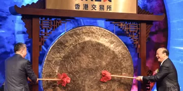 Zeng Yuqun, Chairman of Chinese battery giant CATL (R) bangs a gong to start CATL's debut trading on the Hong Kong stock exchange, in Hong Kong on May 20, 2025. Shares in Chinese battery giant CATL soared 13 percent on its Hong Kong debut on May 20 after raising US$4.6 billion in what is said to be the world's biggest initial public offering this year. (Photo by Peter PARKS / AFP)