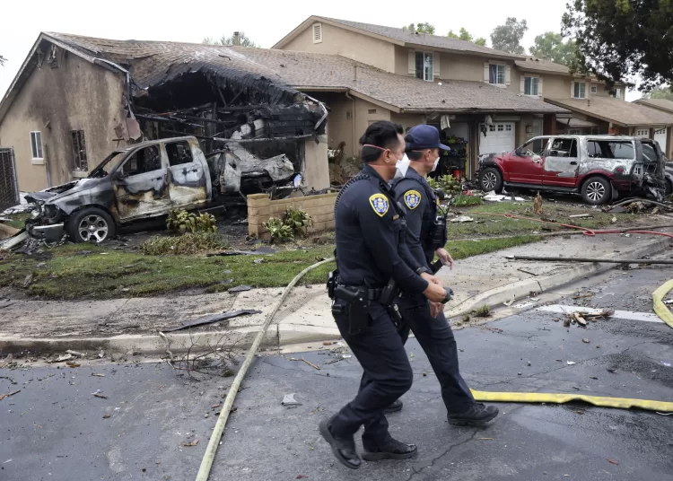 Police officers search the site where a small plane crashed on a San Diego, California, residential street on May 22, 2025. The Federal Aviation Authority said a Cessna 550 crashed at around 3:45 am local time. The neighborhood is close to the Montgomery-Gibbs Executive Airport. The crash left a "gigantic debris field" and damaged some 15 homes and parked cars, ABC News quoted the San Diego assistant fire chief as saying. (Photo by Sandy Huffaker / AFP)