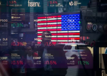 Monitors display stock market information as pedestrians are reflected in a window at the Nasdaq MarketSite in the Times Square area of New York, U.S., on Friday, April 26, 2019. U.S. stocks edged higher on better-than-forecast earnings while Treasury yields fell after data signaled tepid inflation in the first quarter. Photographer: Michael Nagle/Bloomberg via Getty Images