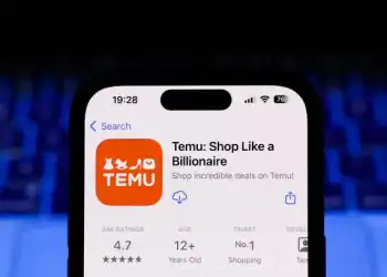 A laptop keyboard and Temu on App Store displayed on a phone screen are seen in this illustration photo taken in Krakow, Poland on March 17, 2025. (Photo by Jakub Porzycki/NurPhoto via Getty Images)