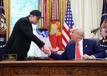 EO Elon Musk shakes hands with U.S. President Donald Trump