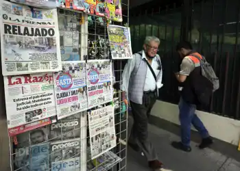 People walk past a newspaper stand the day after the election of judges in Mexico City on June 2, 2025. Mexican President Claudia Sheinbaum hit back Monday at criticism of her country's unprecedented election of judges, after most voters skipped a ballot that her opponents called a farce. (Photo by Alfredo ESTRELLA / AFP)
