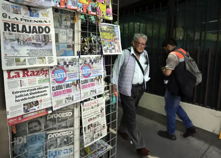 People walk past a newspaper stand the day after the election of judges in Mexico City on June 2, 2025. Mexican President Claudia Sheinbaum hit back Monday at criticism of her country's unprecedented election of judges, after most voters skipped a ballot that her opponents called a farce. (Photo by Alfredo ESTRELLA / AFP)