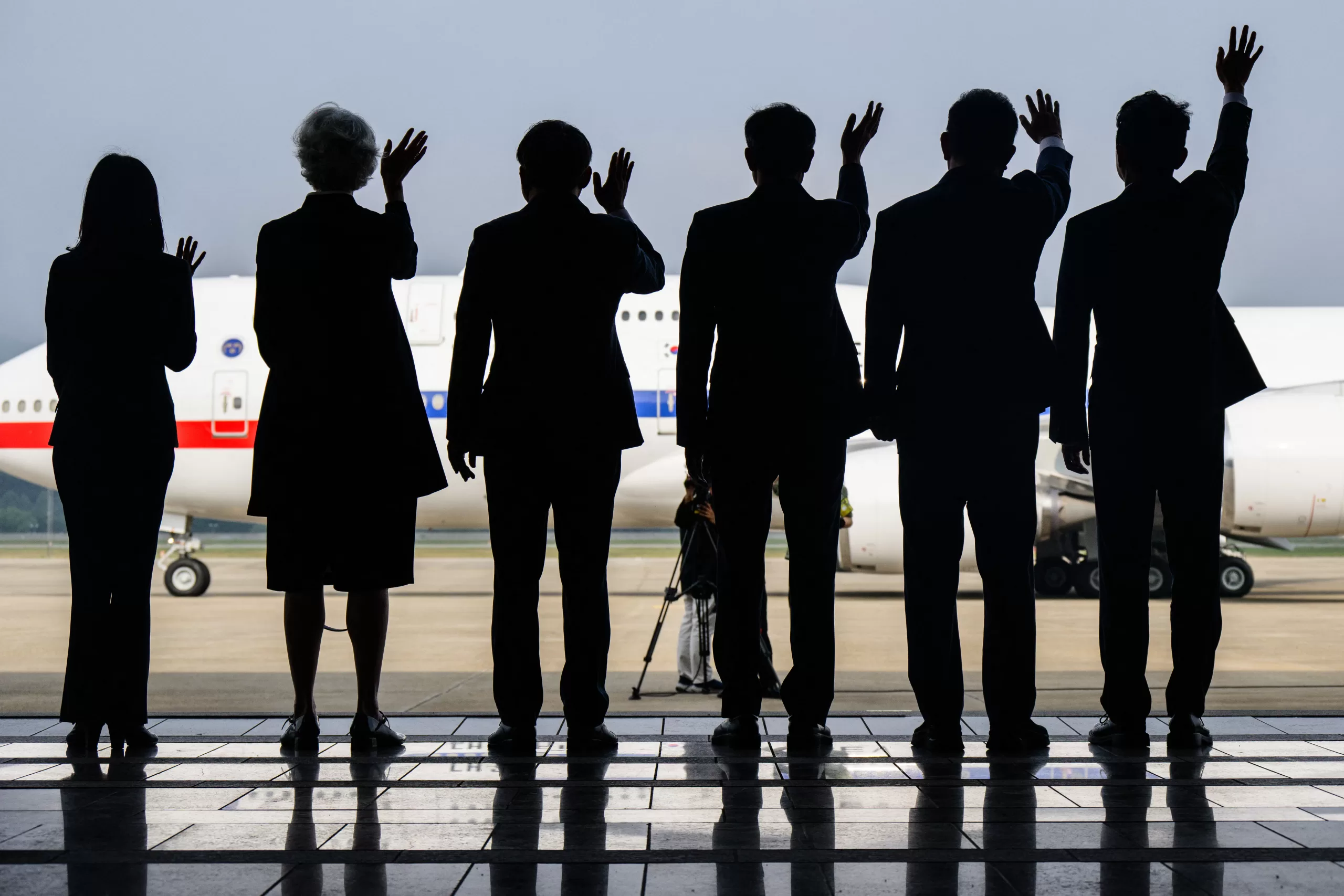 Guests wave during the departure of South Koreas President Lee Jae-myung and his wife, First Lady Kim Hye-gyeong in their plane at Seoul Air Base in Seongnam on June 16, 2025, before departing for Canada to attend the G7 summit. (Photo by ANTHONY WALLACE / AFP)