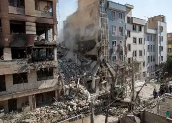 TEHRAN, IRAN - JUNE 13: An excavator removes debris from a residential building that was destroyed in today's attack by Israel in Tehran, on June 13, 2025 in Tehran, Iran. Early this morning, Iran was hit by a series of Israeli airstrikes targeting military and nuclear sites, as well as top military officials. (Photo by Majid Saeedi/Getty Images)