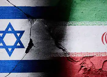 Israeli and Iranian flags are seen in this illustration photo taken in Warsaw, Poland on 16 June, 2025. A missile struck the Islamic Republic of Iran News Network (IRINN) during a live broadcast showing destruction of the studio and the reporter escaping to safety. (Photo by Jaap Arriens/NurPhoto via Getty Images)