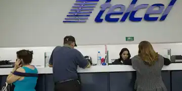 Employees assist customers at an America Movil SAB Telcel service center in Mexico City, Mexico, on Tuesday, July 21, 2015. North America's wireless carriers are in a race to attract customers who make frequent calls and trips between the U.S. and Mexico. America Movil SAB, AT&T Inc., T-Mobile US Inc. and Telefonica Mexico have all introduced plans this year that end cross-border roaming charges and take advantage of a two-country region with more than 400 million people.P hotographer: Susana Gonzalez/Bloomberg via Getty Images