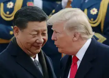 President Trump chats with Chinese President Xi Jinping during a visit to Beijing in 2017. Andy Wong/AP