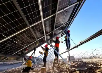 ZHANGYE, CHINA - JANUARY 16: Workers install solar panels at the construction site of a 100,000 kilowatt photovoltaic power generation project on January 16, 2024 in Shandan County, Zhangye City, Gansu Province of China. (Photo by VCG/VCG via Getty Images)