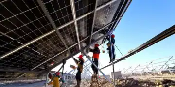 ZHANGYE, CHINA - JANUARY 16: Workers install solar panels at the construction site of a 100,000 kilowatt photovoltaic power generation project on January 16, 2024 in Shandan County, Zhangye City, Gansu Province of China. (Photo by VCG/VCG via Getty Images)