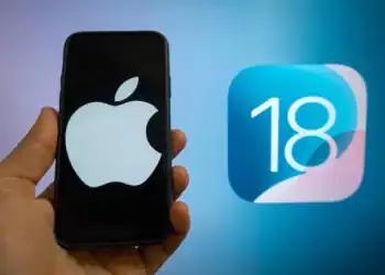 The Apple logo is seen with the iOS 18 operating system logo in the background on a mobile device in this illustration photo taken in L'Aquila, Italy, on June 20th, 2024.  (Photo by Lorenzo Di Cola/NurPhoto via Getty Images)