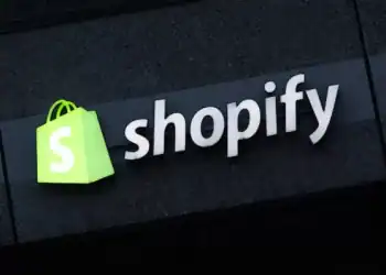 BERLIN, GERMANY - DECEMBER 14: The corporate logo of e-commerce company Shopify hangs at the building that contains the offices of Shopify Commerce Germany GmbH on December 14, 2023 in Berlin, Germany. Shopify is a leading, Canada-based company that enables online and brick-and-mortar commerce. (Photo by Sean Gallup/Getty Images)