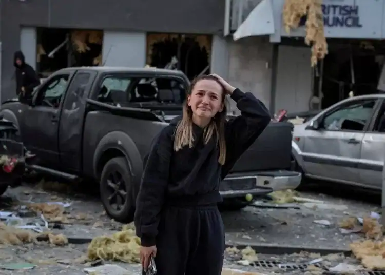 Una mujer cerca del lugar del ataque ruso, que dañó los edificios de apartamentos y el Consejo Británico. FOTO: STRINGER/REUTERS