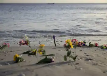 Flores en la playa durante un acto en memoria de los migrantes fallecidos en el mar realizada el 6 de febrero de 2025 en la playa de Mbao, en Senegal (PATRICK MEINHARDT)