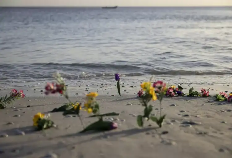 Flores en la playa durante un acto en memoria de los migrantes fallecidos en el mar realizada el 6 de febrero de 2025 en la playa de Mbao, en Senegal (PATRICK MEINHARDT)