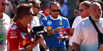 MONZA, ITALY - SEPTEMBER 06: Lewis Hamilton of Great Britain and Scuderia Ferrari signs autographs for fans prior to final practice ahead of the F1 Grand Prix of Italy at Autodromo Nazionale Monza on September 06, 2025 in Monza, Italy. (Photo by Clive Rose/Getty Images)