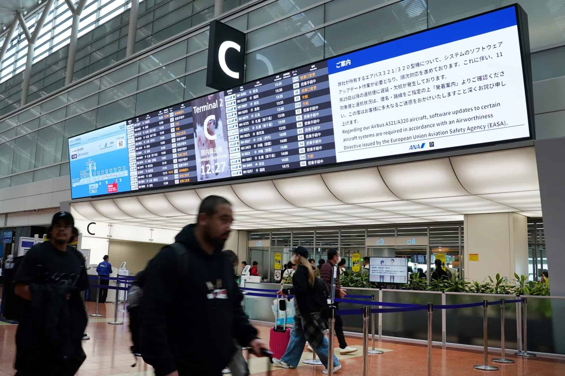 Un tablón de anuncios en el vestíbulo de facturación de All Nippon Airways (ANA) muestra un aviso de que se requirió una actualización de software para el avión Airbus A321/A320 de la aerolínea, lo que resultaría en retrasos y cancelaciones de vuelos, en el aeropuerto de Haneda en Tokio el 29 de noviembre de 2025. Varias aerolíneas anunciaron vuelos retrasados o cancelados después de una alerta de Airbus de que hasta 6.000 aviones de la familia A320 operativos pueden requerir mejoras. (Foto de Kazuhiro NOGI / AFP)