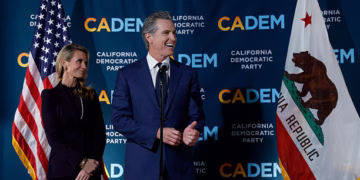 SACRAMENTO, CALIFORNIA - NOVEMBER 04: California Gov. Gavin Newsom (R) speaks as his wife Jennifer Siebel Newsom (L) looks on during an election night gathering at the California Democratic Party headquarters on November 04, 2025 in Sacramento, California. California voters approved Proposition 50, a measure that will replace the state’s current congressional district map with new, legislature-drawn lines from 2026 through 2030.  (Photo by Justin Sullivan/Getty Images)