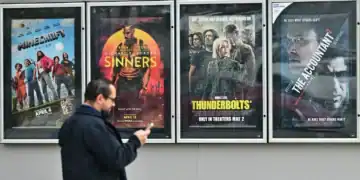 Un hombre pasa junto a carteles de películas en el Teatro AMC en Montebello, California, el 5 de mayo de 2025. Frederic J. Marrón | AFP | Getty Images