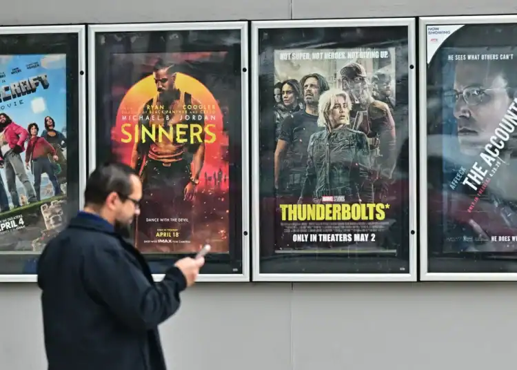 Un hombre pasa junto a carteles de películas en el Teatro AMC en Montebello, California, el 5 de mayo de 2025. Frederic J. Marrón | AFP | Getty Images