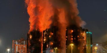 (FILES) Thick smoke and flames rise as a major fire engulfs several apartment blocks at the Wang Fuk Court residential estate in Hong Kong's Tai Po district on November 26, 2025. Hong Kong police said on December 1 they had arrested a total of 13 people for manslaughter over a deadly fire that ripped through an apartment complex last week, killing at least 146. (Photo by Yan ZHAO / AFP)