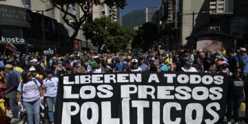 (ARCHIVOS) Los manifestantes sostienen una pancarta exigiendo la liberación de todos los presos políticos durante una protesta convocada por la oposición en la víspera de la inauguración presidencial, en Caracas el 9 de enero de 2025. Al menos 60 detenidos después de las elecciones fueron liberados de prisión el 25 de diciembre de 2025, informó una organización no gubernamental compuestada por activistas de derechos humanos y familiares de presos políticos. Los liberados habían sido arrestados en medio de la crisis política provocada por la reelección del presidente Nicolás Maduro en julio de 2024 para un tercer mandato en medio de acusaciones de fraude de la oposición. (Foto de JUAN BARRETO / AFP)