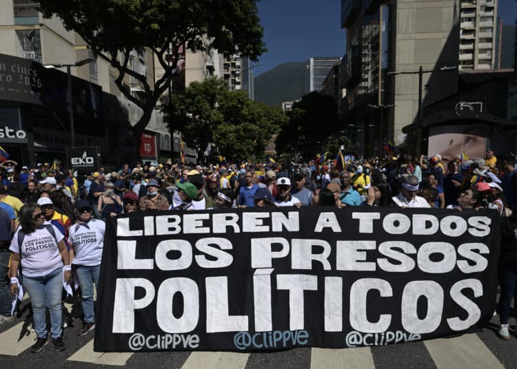 (ARCHIVOS) Los manifestantes sostienen una pancarta exigiendo la liberación de todos los presos políticos durante una protesta convocada por la oposición en la víspera de la inauguración presidencial, en Caracas el 9 de enero de 2025. Al menos 60 detenidos después de las elecciones fueron liberados de prisión el 25 de diciembre de 2025, informó una organización no gubernamental compuestada por activistas de derechos humanos y familiares de presos políticos. Los liberados habían sido arrestados en medio de la crisis política provocada por la reelección del presidente Nicolás Maduro en julio de 2024 para un tercer mandato en medio de acusaciones de fraude de la oposición. (Foto de JUAN BARRETO / AFP)