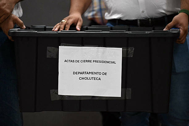 Miembros del Partido Liberal del candidato presidencial Salvador Nasralla sostienen una caja con hojas de recuento electoral del departamento de Choluteca en Tegucigalpa el 3 de diciembre de 2025. El presentador de televisión hondureña Salvador Nasralla amplió una estrecha ventaja el 3 de diciembre sobre el rival respaldado por Trump, Nasry Asfura, ya que el recuento de votos emitidos en una elección presidencial de fin de semana se arrastró a un tercer día. (Foto de Marvin RECINOS / AFP vía Getty Images)