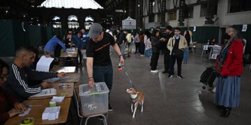 Un hombre con un perro emitió su voto durante la segunda sedición de las elecciones presidenciales en la Estación de Mapocho en Santiago el 14 de diciembre de 2025. Los chilenos se dirigen a las urnas para una resección presidencial entre Jeannette Jara, una comunista respaldada por una amplia coalición de izquierda, y José Antonio Kast, un devoto político de extrema derecha que promete una línea dura en seguridad y migración. (Foto de Eitan ABRAMOVICH / AFP vía Getty Images)