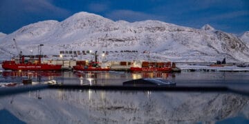 (ARCHIVOS) El puerto y la montaña detrás se reflejan en una ventana en Nuuk, Groenlandia, el 7 de marzo de 2025. El presidente de los Estados Unidos, Donald Trump, está discutiendo opciones que incluyen acciones militares para tomar el control de Groenlandia, dijo la Casa Blanca el 6 de enero de 2025, aumentando las tensiones que Dinamarca advierte que podrían destruir la alianza de la OTAN. Trump ha intensificado sus planes en el territorio danés autónomo rico en minerales en el Ártico desde que el ejército estadounidense capturó al líder venezolano Nicolás Maduro el 3 de enero de 2026. (Foto de Odd ANDERSEN / AFP)