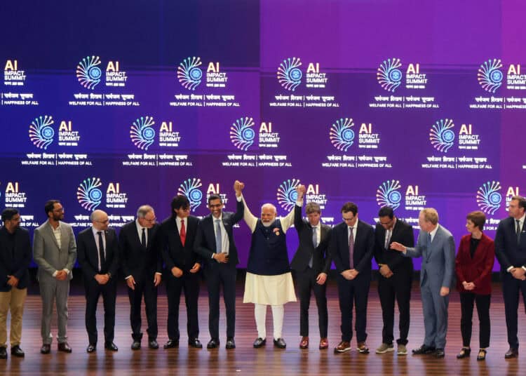 El primer ministro de la India, Narendra Modi (C), se toma una foto de grupo con líderes de empresas de IA en la Cumbre de Impacto de IA en Nueva Delhi el 19 de febrero de 2026. (Foto de Ludovic MARIN / AFP)