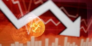 Una representación física de Bitcoin y una flecha del tipo de cambio aparecen en la pantalla de un ordenador como fondo en esta ilustración fotográfica en Atenas, Grecia, el 5 de febrero de 2026. Bitcoin está a punto de romperse por debajo del nivel clave de 70.000 dólares el jueves, ya que una caída en la criptomoneda más grande del mundo no muestra signos de detenerse. Bitcoin cae un 2 % en el comercio europeo temprano, habiendo caído hasta un 3,5 % antes durante la sesión asiática a 70.052,38 dólares, su nivel más bajo desde noviembre de 2024. (Foto de Nikolas Kokovlis/NurPhoto a través de Getty Images)