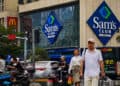 Personas caminando por las calles de Estados Unidos frente a un Sams club