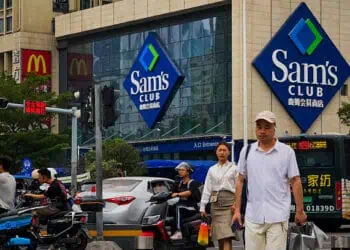 Personas caminando por las calles de Estados Unidos frente a un Sams club